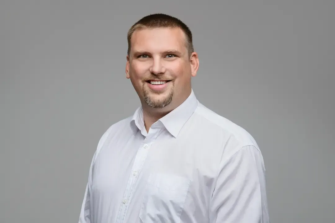 breitbandtechnik team – Klaus Lochner im Porträt vor grauem Hintergrund