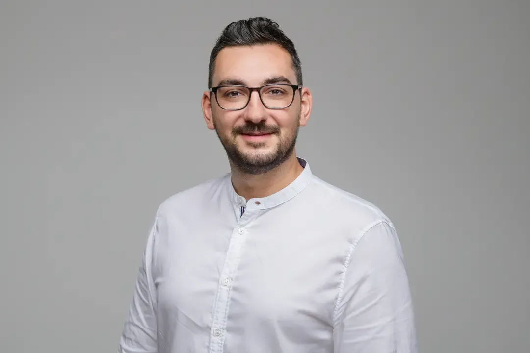 breitbandtechnik team – Stamati Kiriazakis im Porträt vor grauem Hintergrund